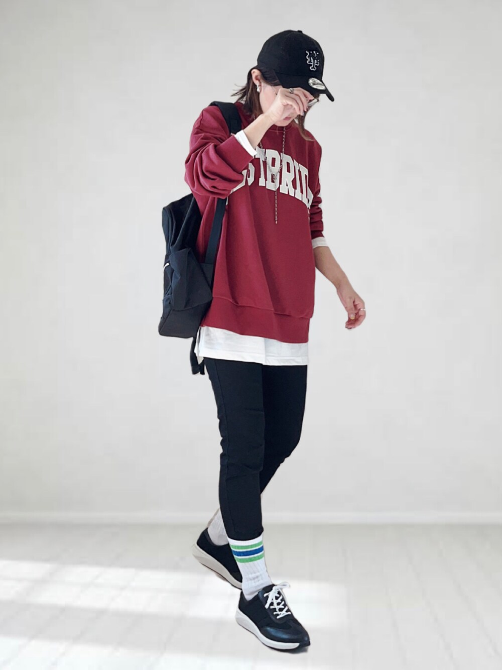 レッド系のTシャツ/カットソー、ホワイト系のTシャツ/カットソー、ブラック系のデニムパンツを着用したレディースの秋コーディネートの1枚目の写真