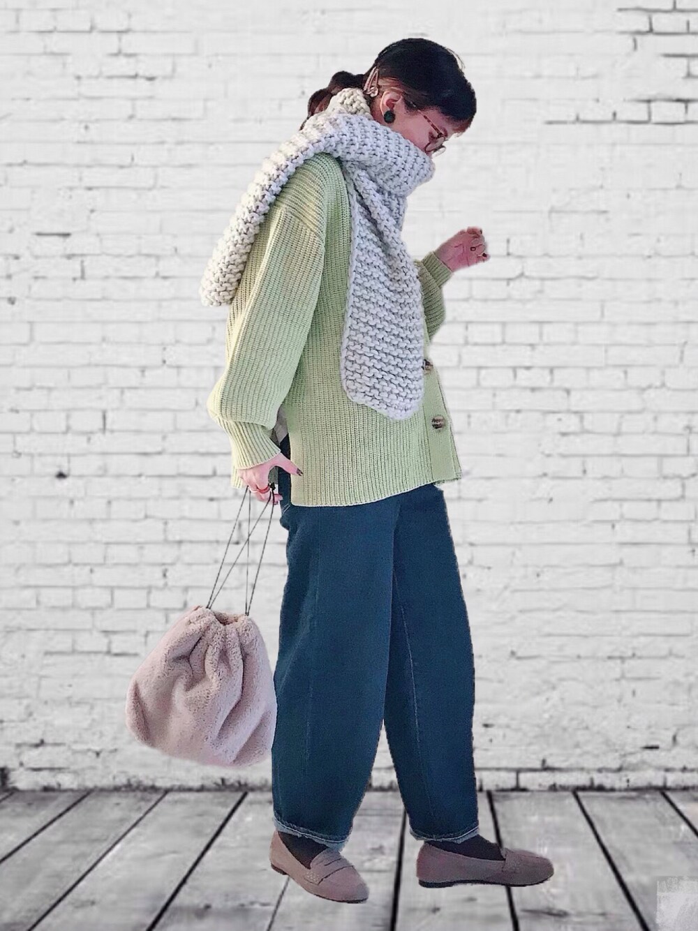 イエロー系のカーディガン/ボレロ、ブルー系のデニムパンツ、ブラック系のショルダーバッグを着用したレディースの秋コーディネートの1枚目の写真