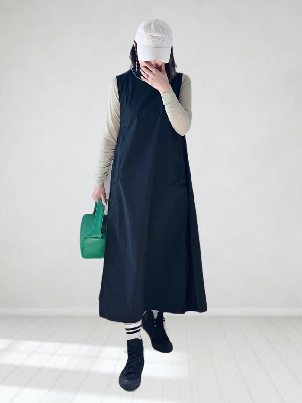 ブラック系のワンピース、グリーン系のTシャツ/カットソー、グリーン系のショルダーバッグを着用したレディースの春コーディネートの1枚目の写真