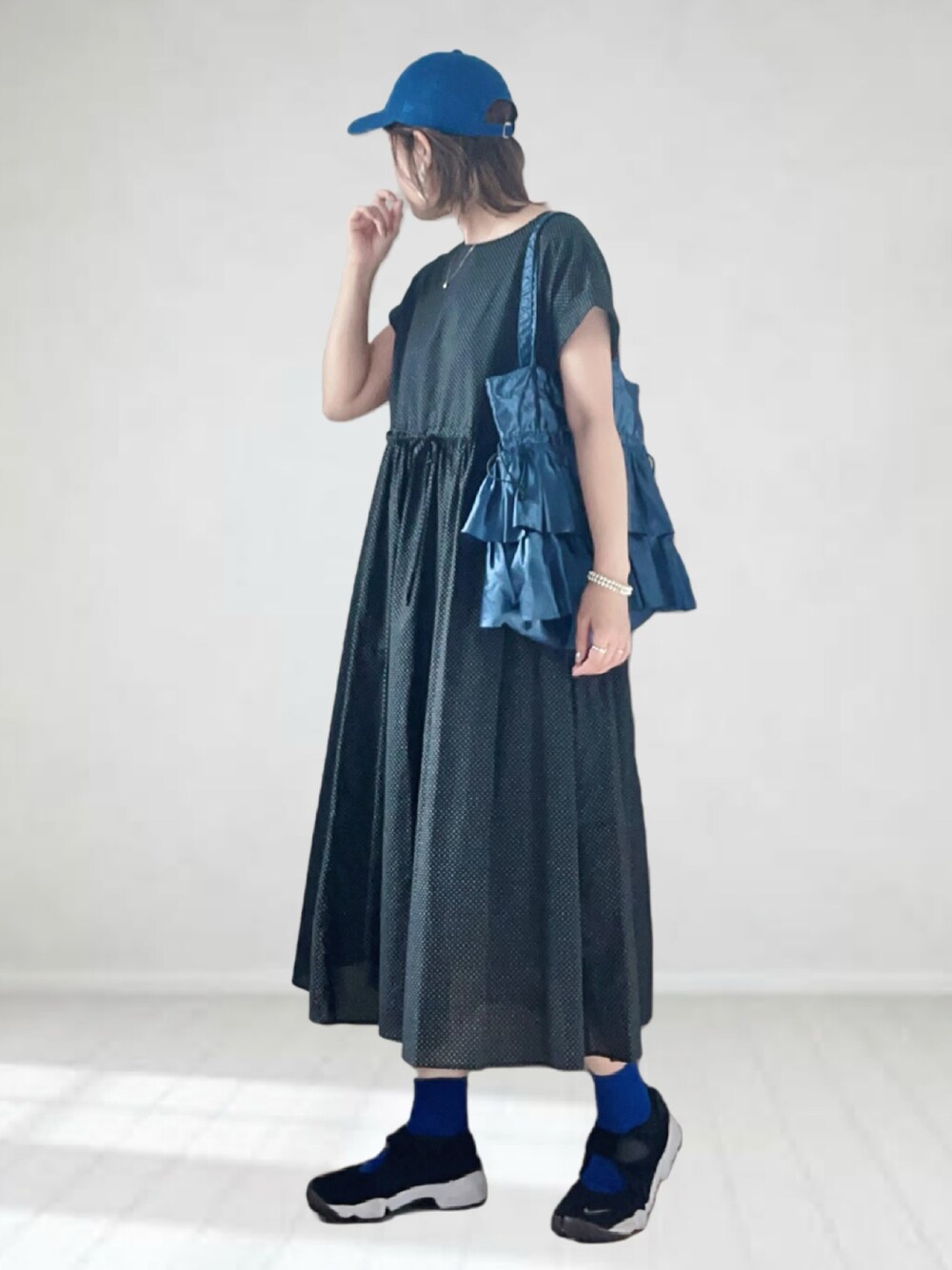 ブラック系のワンピース、ブルー系のバッグ、ブラック系のサンダルを着用したレディースの夏コーディネートの1枚目の写真