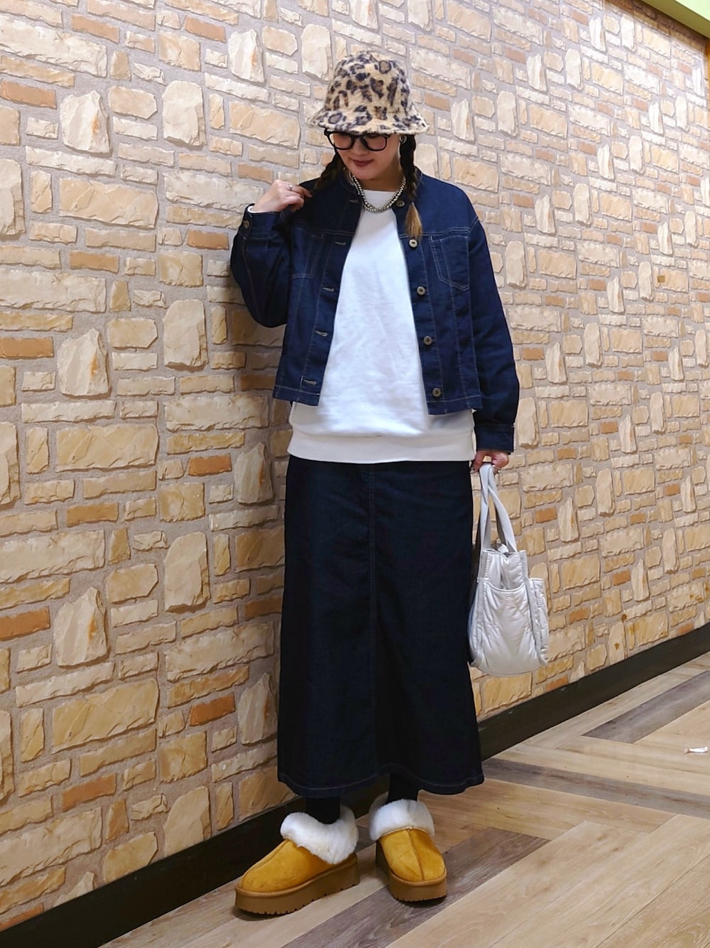 ブルー系のブルゾン、ホワイト系のトートバッグ、イエロー系のブーツを着用したレディースの冬コーディネートの1枚目の写真