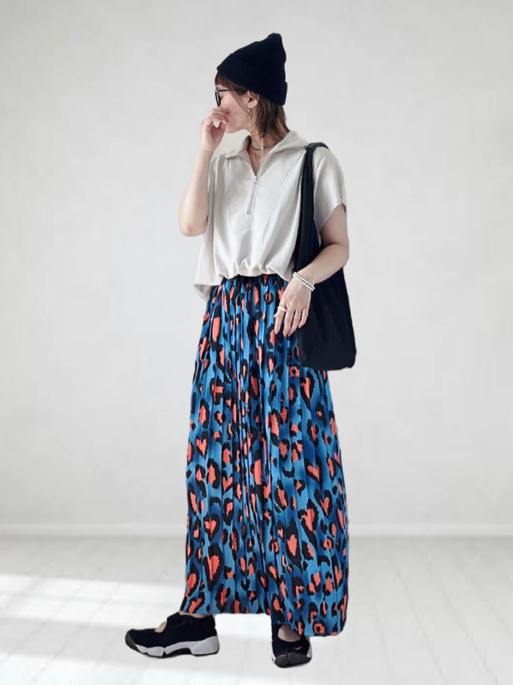 ブルー系のスカート、ベージュ系のTシャツ/カットソー、ブラック系のトートバッグを着用したレディースの夏コーディネートの1枚目の写真