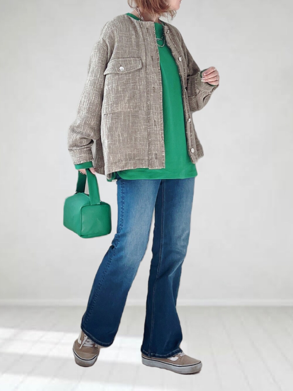 ブルー系のデニムパンツ、グリーン系のTシャツ/カットソー、グリーン系のショルダーバッグを着用したレディースの春コーディネートの1枚目の写真