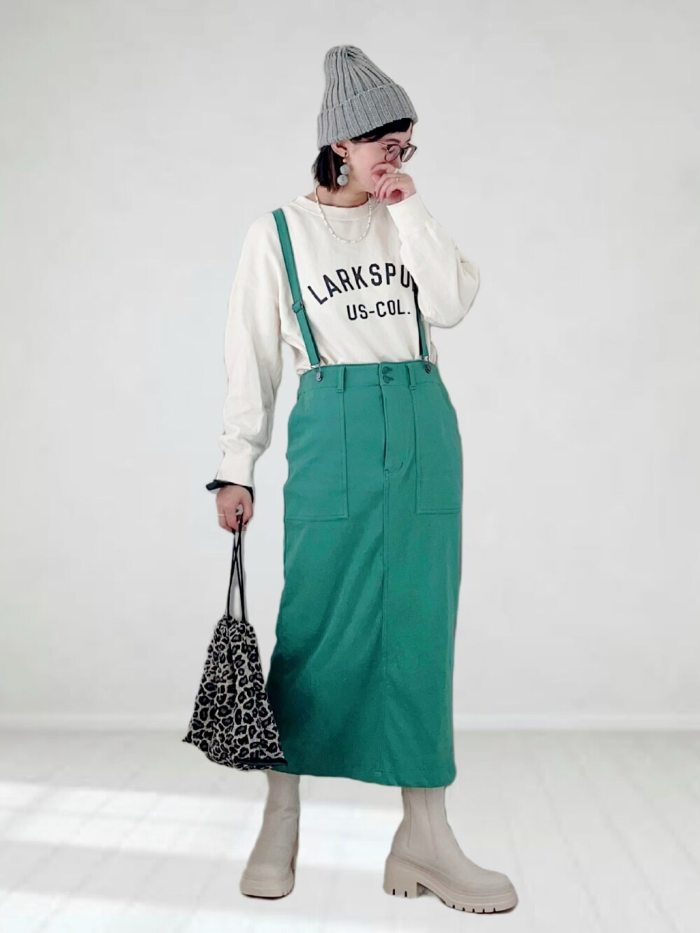 ホワイト系のブーツ、ホワイト系のスウェット、グリーン系のスカートを着用したレディースの秋コーディネートの1枚目の写真