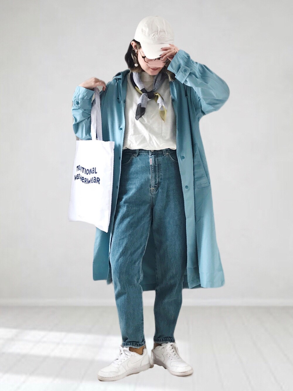 ホワイト系のニット/セーター、ブルー系のデニムパンツ、ホワイト系のトートバッグを着用したレディースの春コーディネートの1枚目の写真