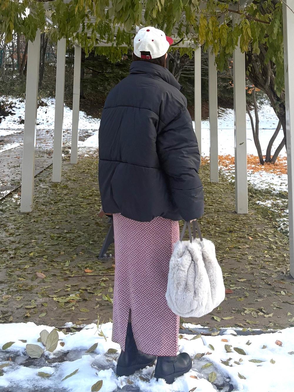 ブラック系のダウンジャケット/コート、ベージュ系のショルダーバッグ、ブラック系のブーツを着用したレディースの冬コーディネートの1枚目の写真