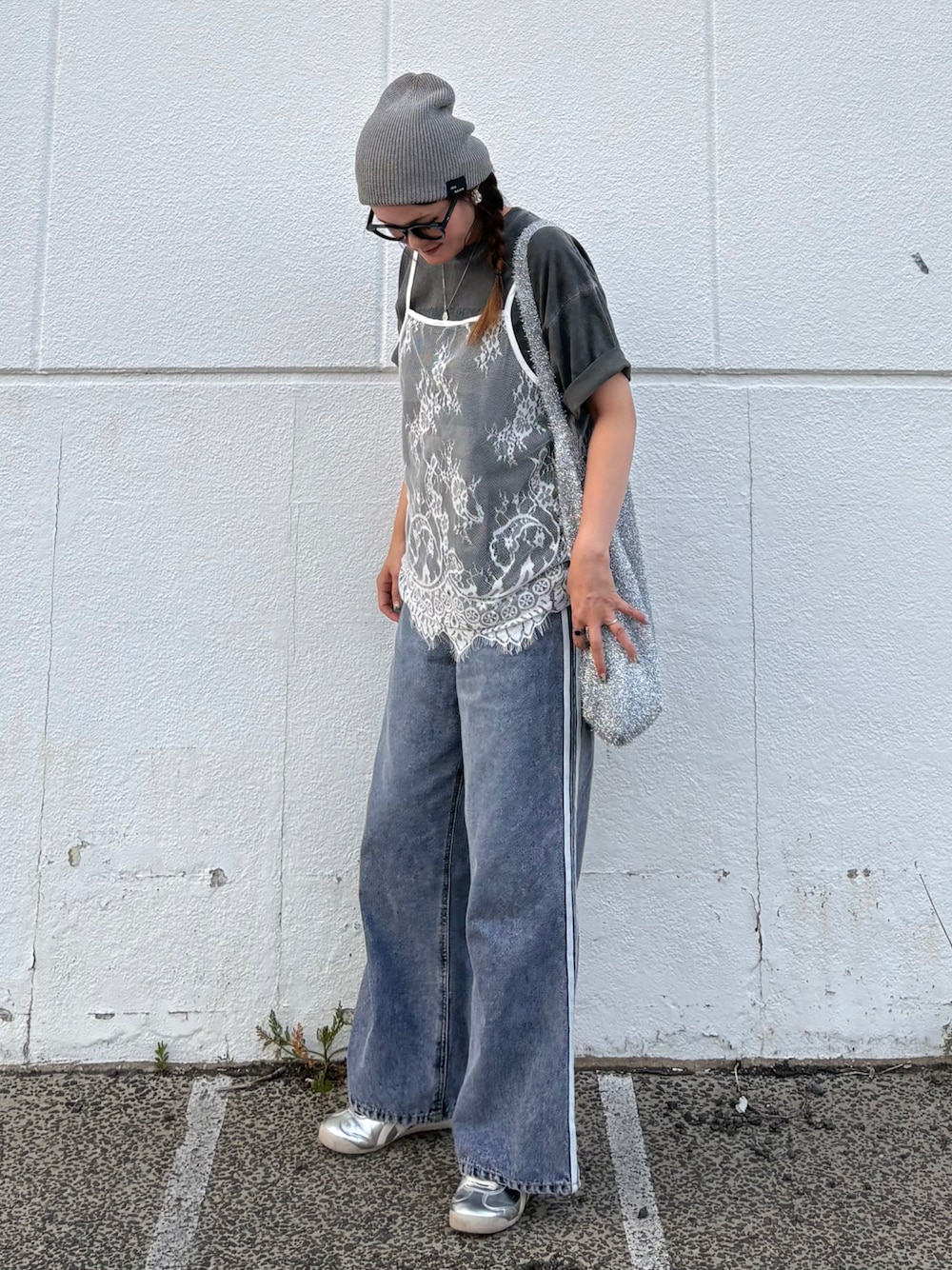ブルー系のデニムパンツ、シルバー系のトートバッグ、シルバー系のスニーカーを着用したレディースの夏コーディネートの1枚目の写真