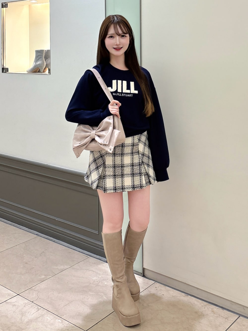 ブルー系のスウェット、ピンク系のショルダーバッグ、ベージュ系のブーツを着用したレディースの秋コーディネートの1枚目の写真