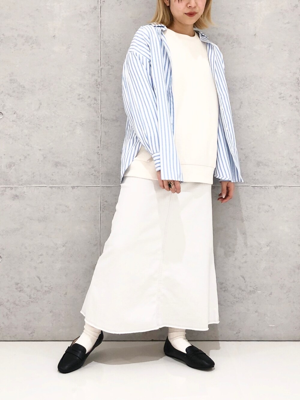 グレー系のスカート、ブラック系のローファー、ホワイト系のスウェットを着用したレディースの冬コーディネートの3枚目の写真