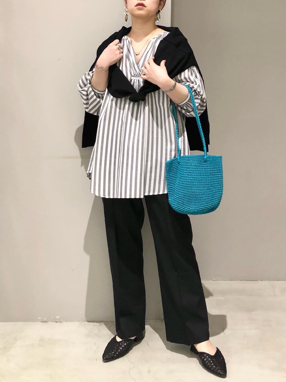 グリーン系のショルダーバッグ、ブラック系のサンダル、ブラック系のその他パンツを着用したレディースの春コーディネートの2枚目の写真