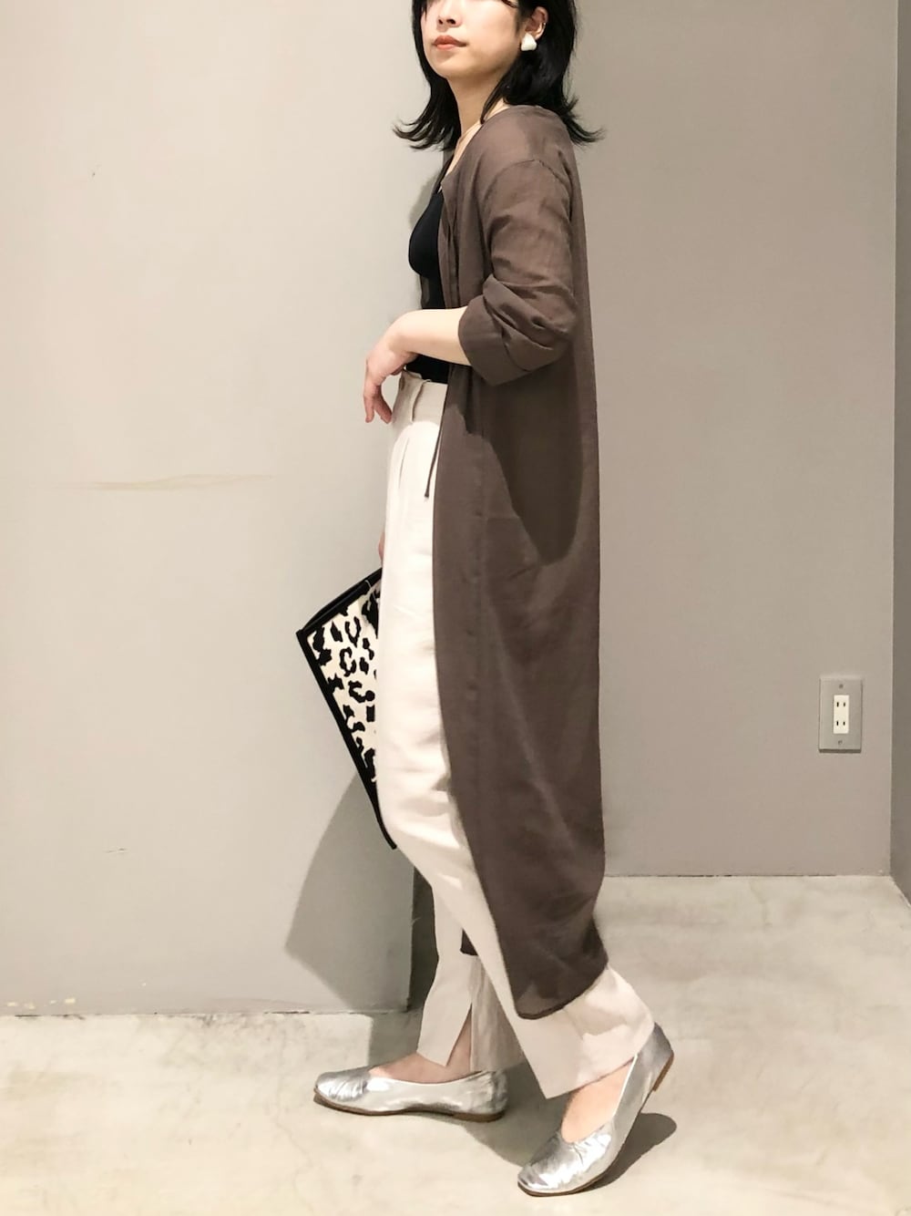 その他のトートバッグ、シルバー系のパンプス、ベージュ系のスラックスを着用したレディースの夏コーディネートの3枚目の写真