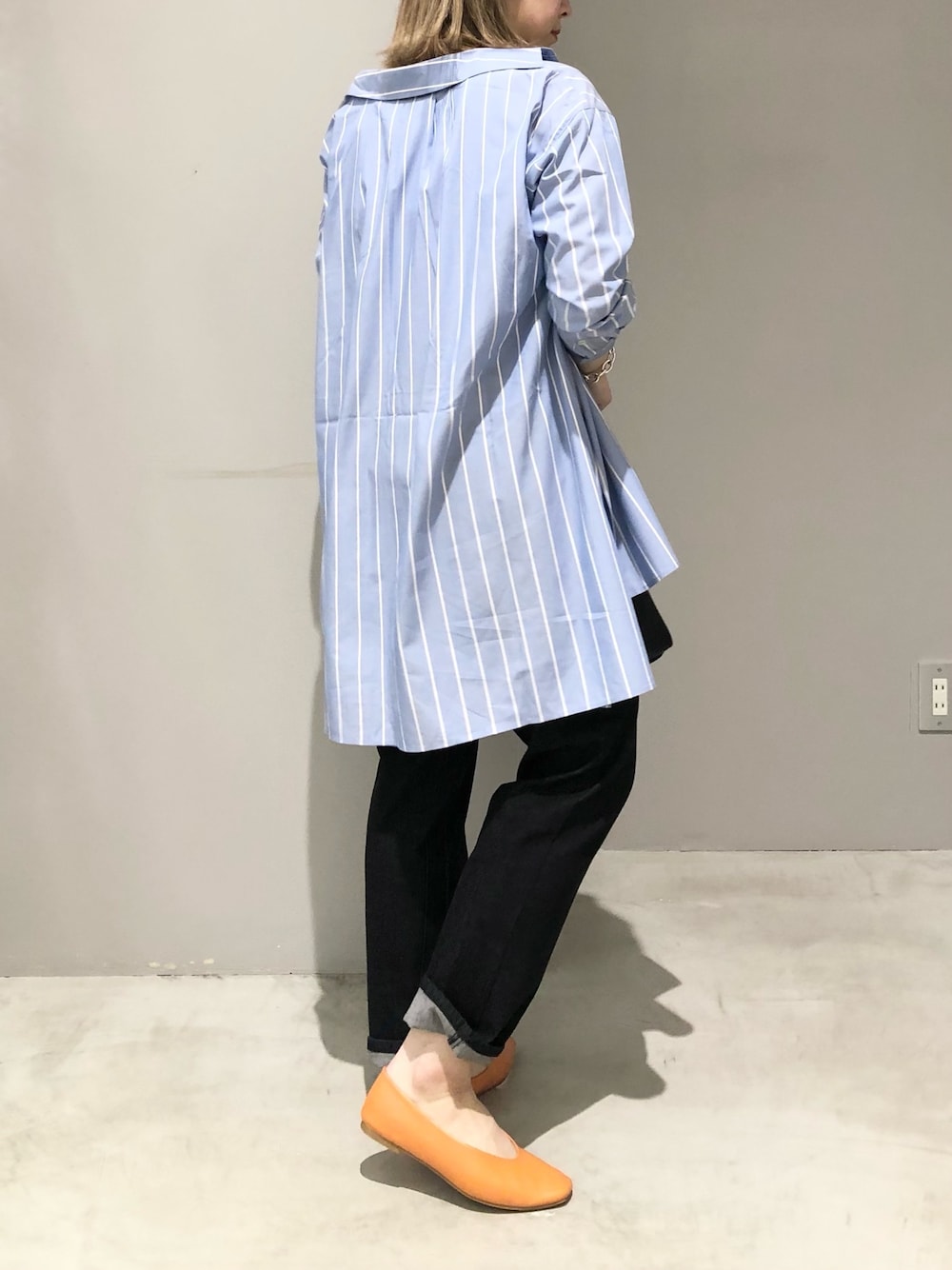 オレンジ系のパンプス、ブラック系のデニムパンツ、ブラック系のショルダーバッグを着用したレディースの春コーディネートの3枚目の写真