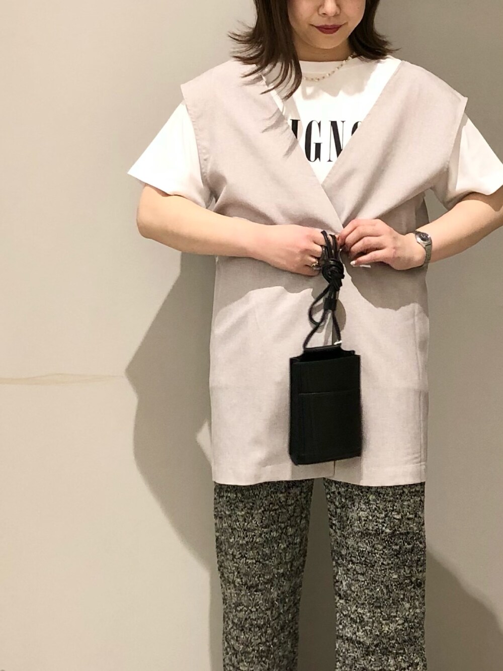 ベージュ系のベスト、ホワイト系のTシャツ/カットソー、ベージュ系のサンダルを着用したレディースの春コーディネートの4枚目の写真