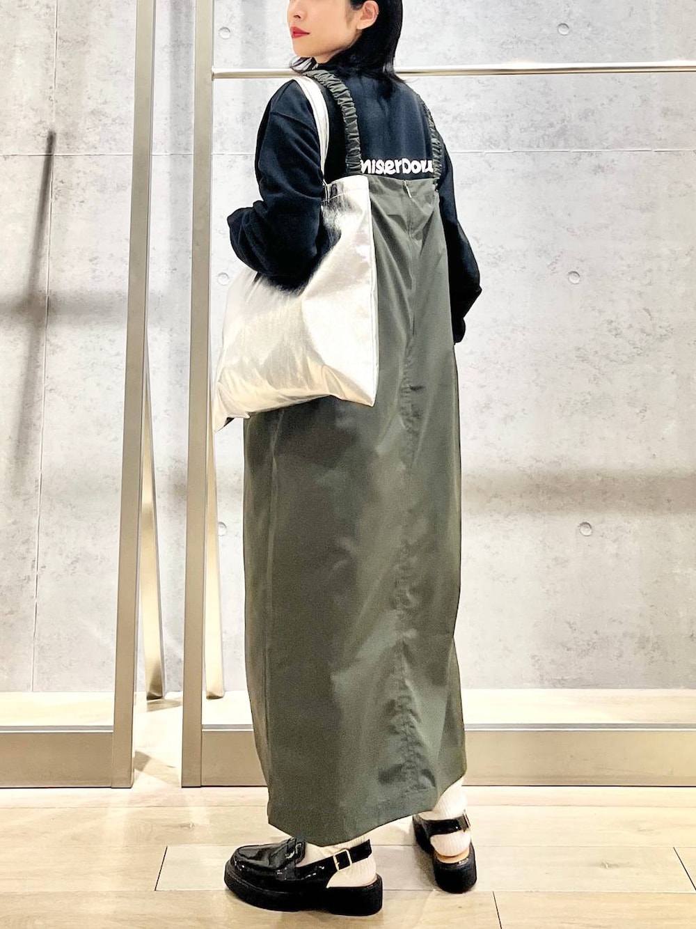 シルバー系のトートバッグ、ブラック系のローファー、ブラック系のスウェットを着用したレディースの冬コーディネートの1枚目の写真