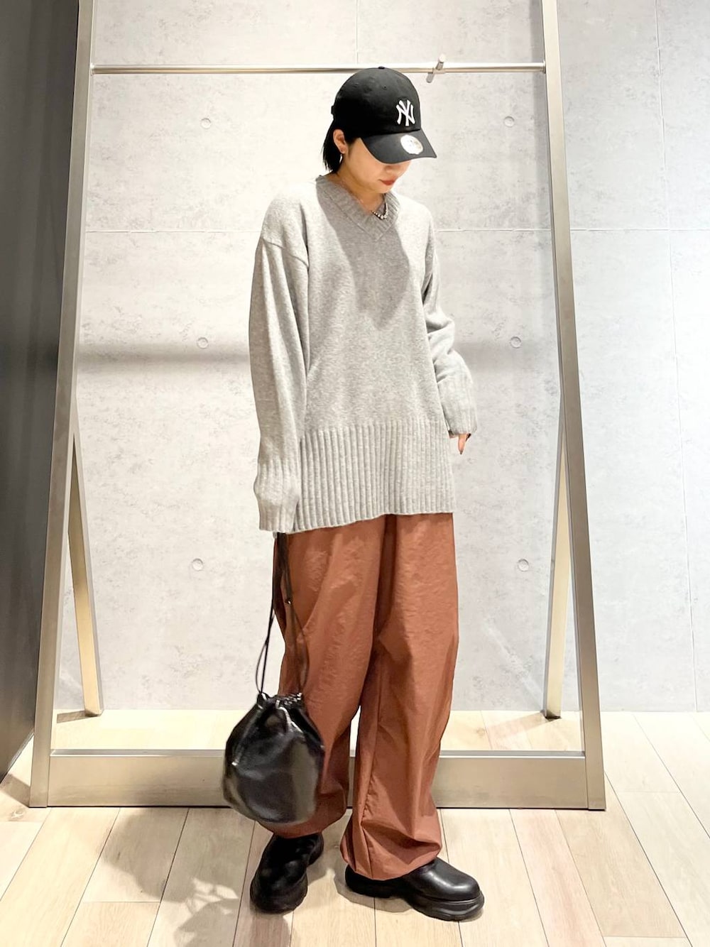 グレー系のその他パンツ、ブラック系のブーツ、グレー系のニット/セーターを着用したレディースの秋コーディネートの1枚目の写真