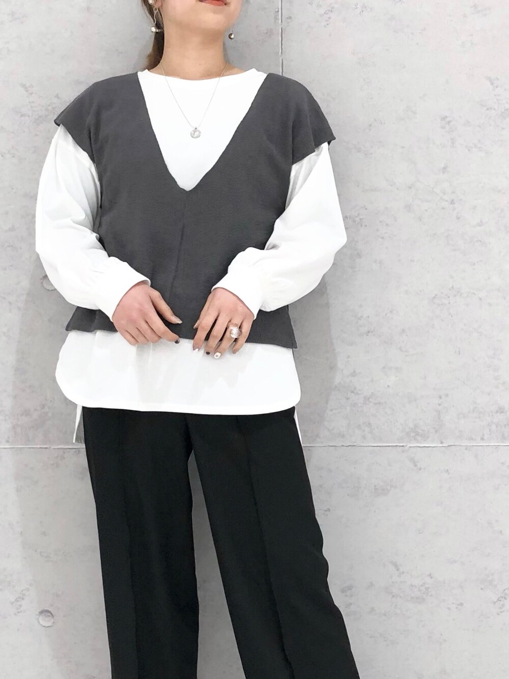 ブラック系のスラックス、ブラウン系のパンプス、ホワイト系のTシャツ/カットソーを着用したレディースの春コーディネートの3枚目の写真