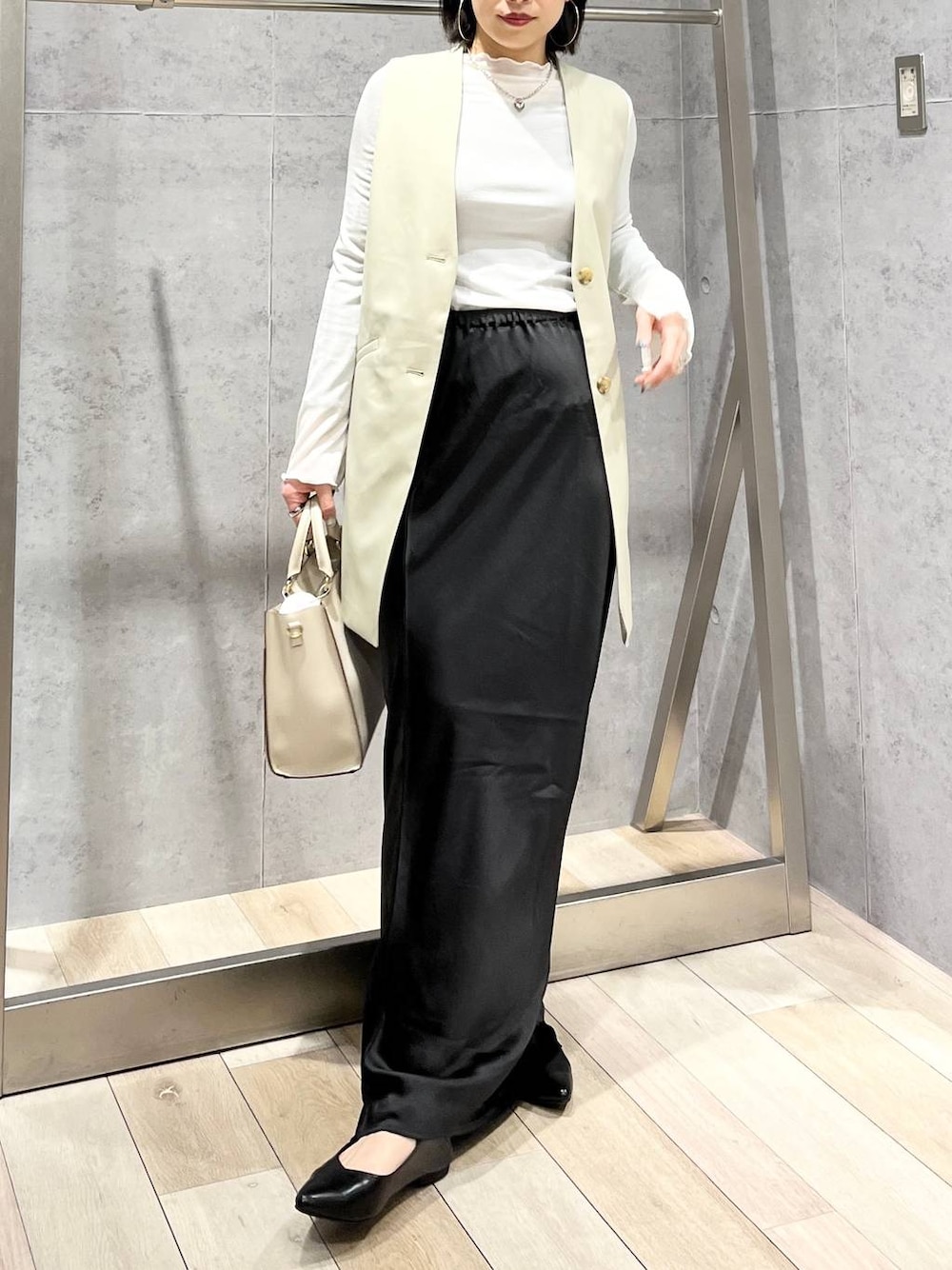 ホワイト系のTシャツ/カットソー、ブラック系のスカート、ホワイト系のショルダーバッグを着用したレディースの冬コーディネートの1枚目の写真