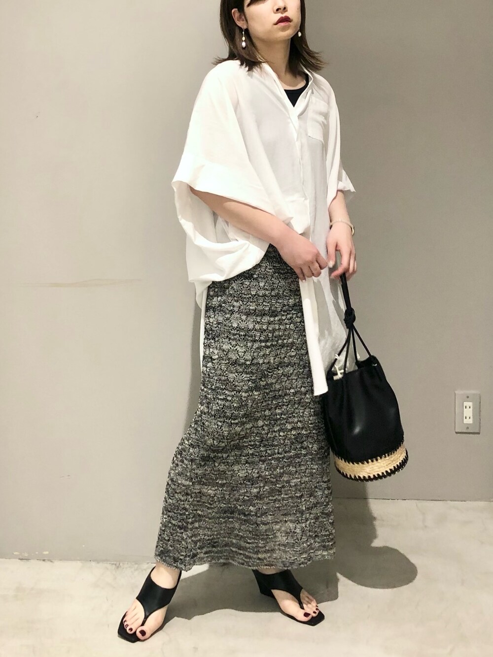 ホワイト系のシャツ/ブラウス、ブラック系のワンピース、ブラック系のかごバッグを着用したレディースの春コーディネートの2枚目の写真