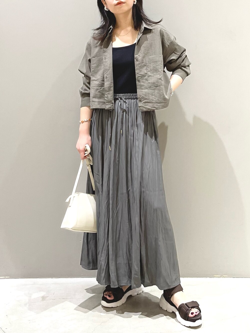 ホワイト系のショルダーバッグ、ブラウン系のサンダル、グレー系のその他パンツを着用したレディースの夏コーディネートの5枚目の写真