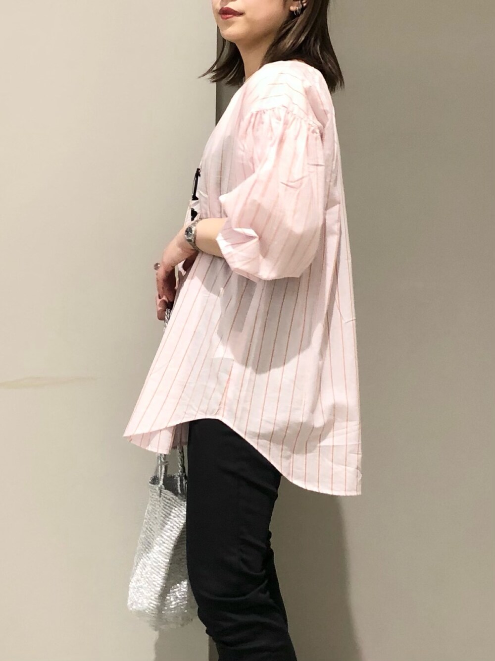 ブラック系のパンツ、イエロー系のサンダル、シルバー系のショルダーバッグを着用したレディースの春コーディネートの5枚目の写真