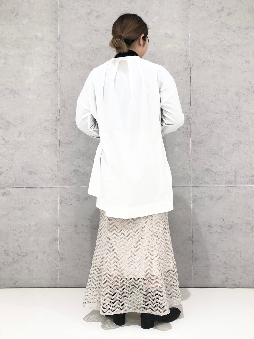 ベージュ系のスカート、ブラック系のショルダーバッグ、ブラック系のブーツを着用したレディースの冬コーディネートの4枚目の写真