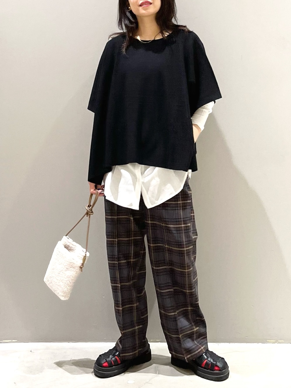 ホワイト系のTシャツ/カットソー、ブラウン系のパンツ、ブラック系のサンダルを着用したレディースの秋コーディネートの1枚目の写真
