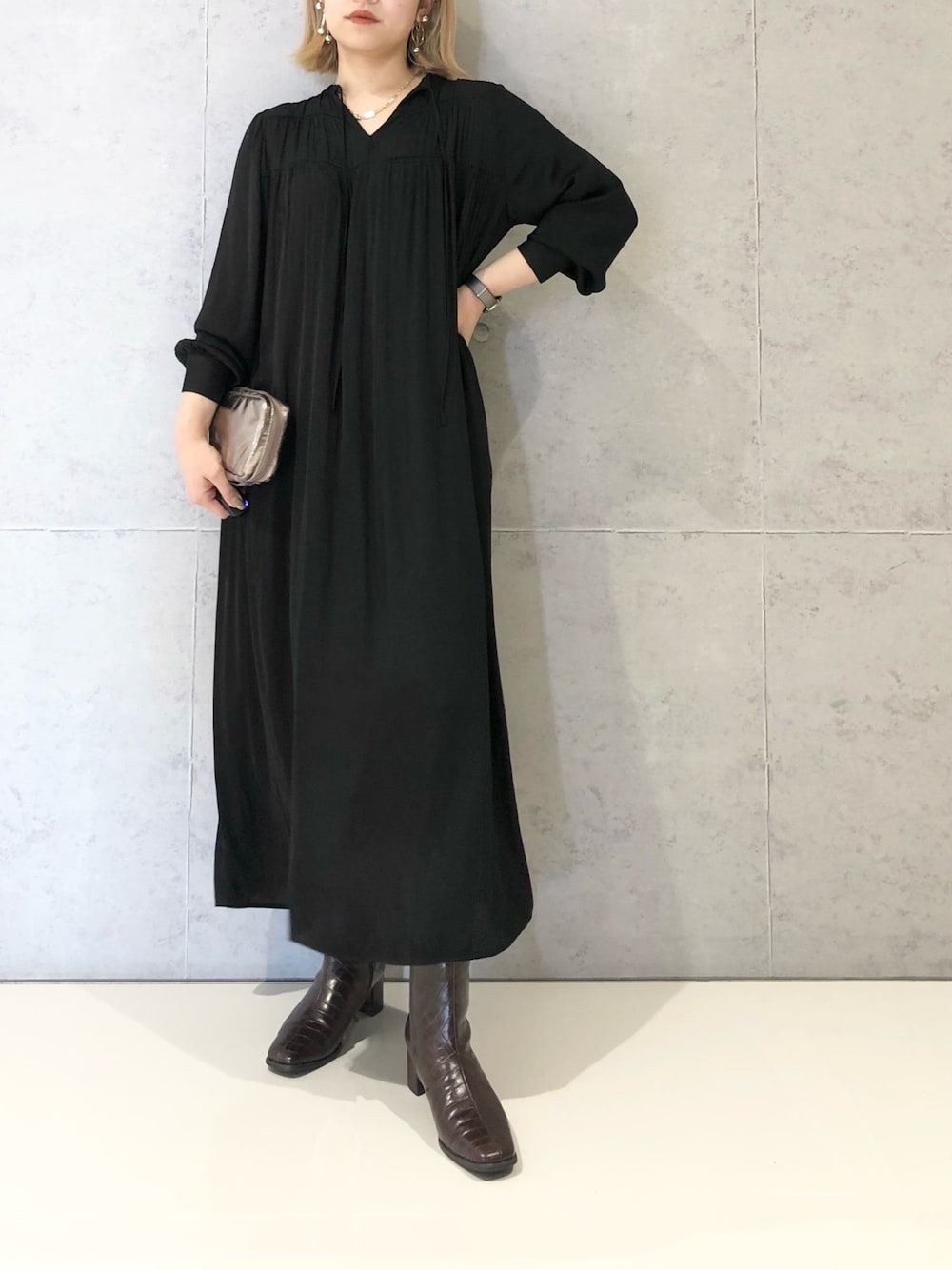 ブラック系のワンピース、ブラウン系のブーツを着用したレディースの冬コーディネートの1枚目の写真