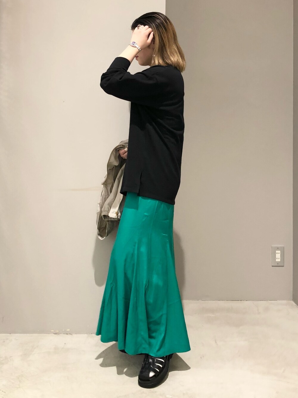 グリーン系のスカート、ブラック系のTシャツ/カットソー、ブラック系のサンダルを着用したレディースの春コーディネートの4枚目の写真