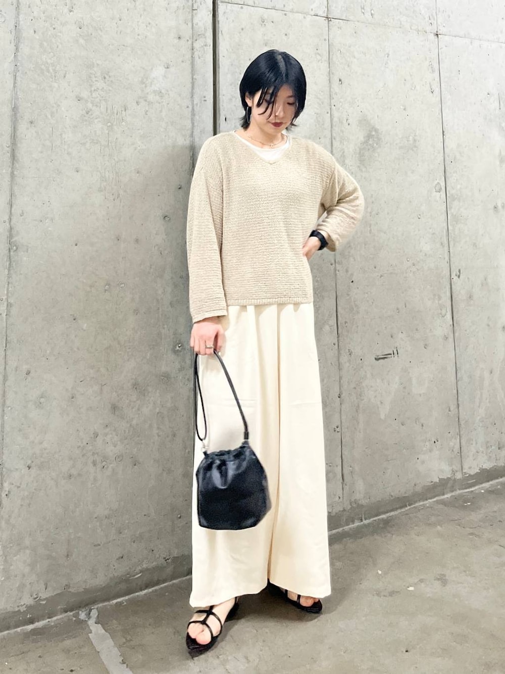 ブラック系のショルダーバッグ、ブラック系のサンダル、ホワイト系のTシャツ/カットソーを着用したレディースの春コーディネートの1枚目の写真