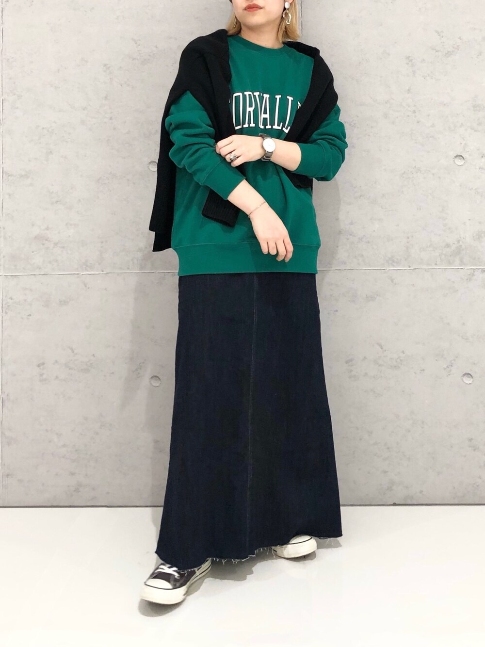 グリーン系のスウェット、ブラック系のカーディガン/ボレロ、ブラック系のスカートを着用したレディースの冬コーディネートの5枚目の写真