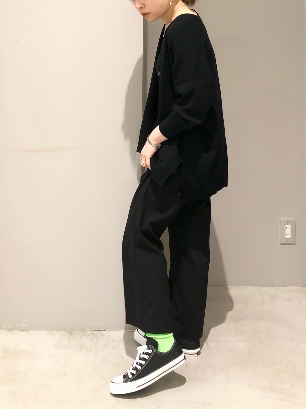 ブラック系のスニーカー、ブラック系のタンクトップ、ブラック系のスラックスを着用したレディースの春コーディネートの3枚目の写真