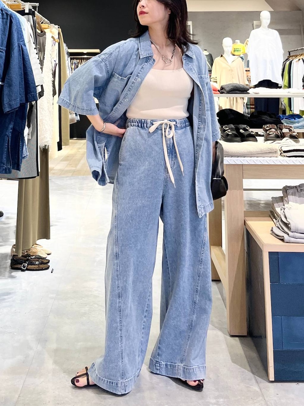 ブルー系のシャツ/ブラウス、ホワイト系のタンクトップ、ブルー系のデニムパンツを着用したレディースの春コーディネートの1枚目の写真