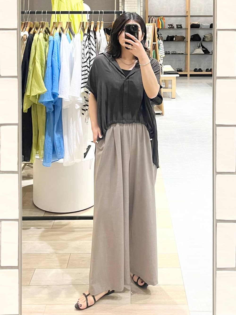 ブラック系のその他パンツ、グレー系のシャツ/ブラウス、ブラウン系のチュニックを着用したレディースの春コーディネートの1枚目の写真