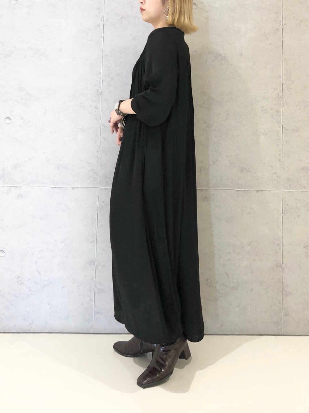 ブラック系のワンピース、ブラウン系のブーツを着用したレディースの冬コーディネートの4枚目の写真