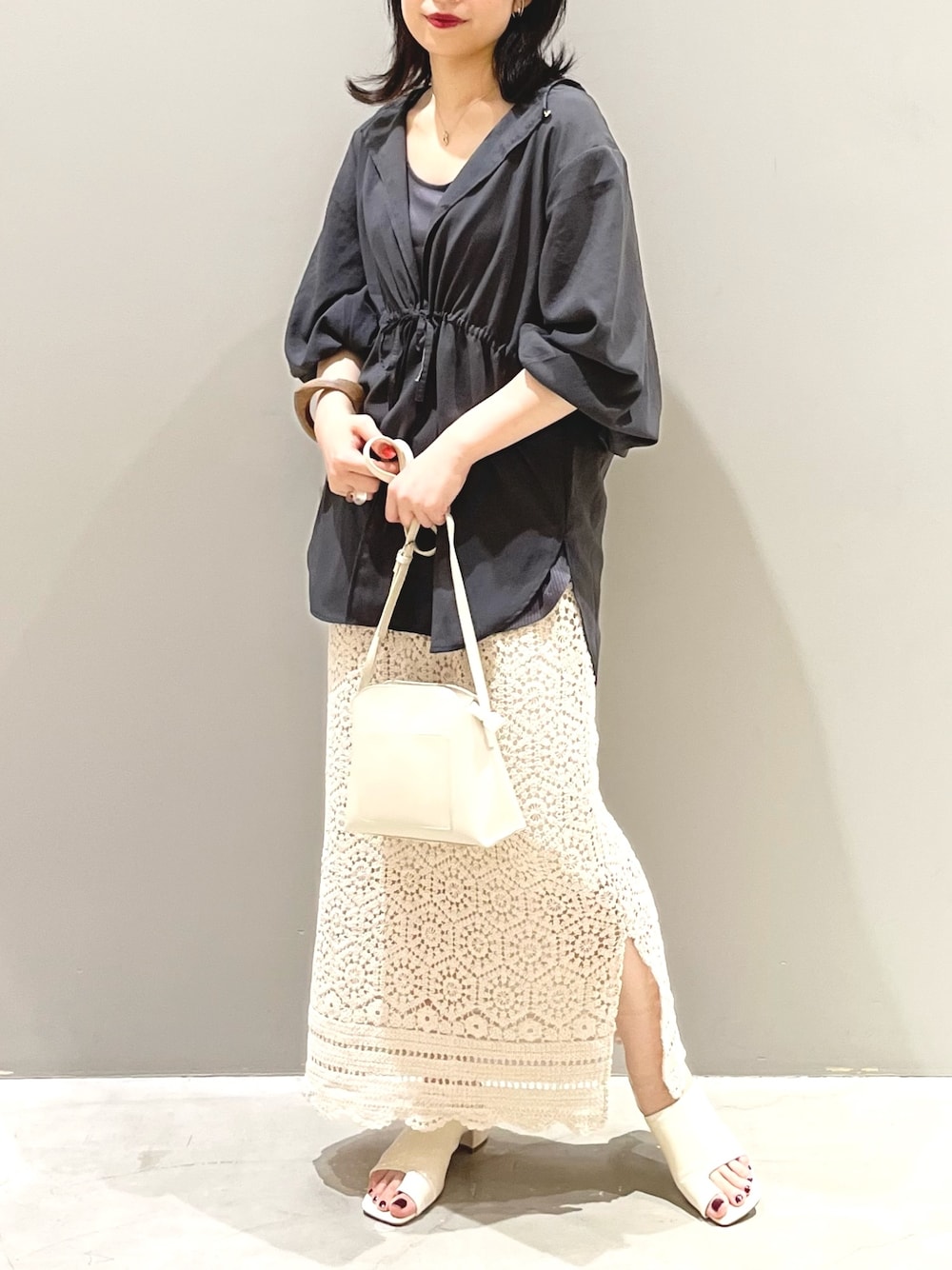 ホワイト系のスカート、ホワイト系のサンダル、ホワイト系のショルダーバッグを着用したレディースの夏コーディネートの1枚目の写真