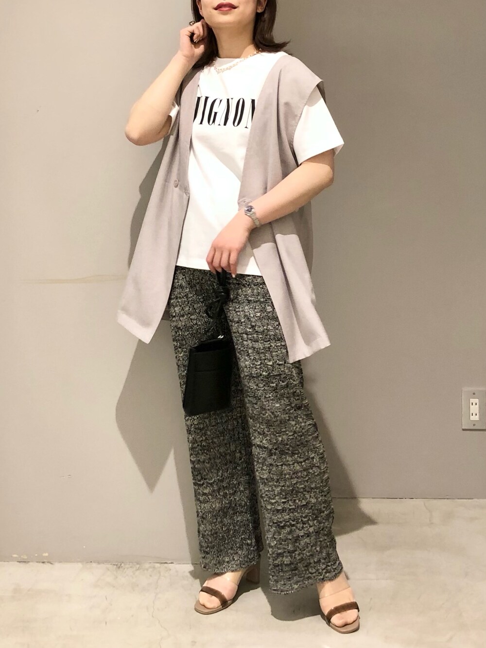 ベージュ系のベスト、ホワイト系のTシャツ/カットソー、ベージュ系のサンダルを着用したレディースの春コーディネートの2枚目の写真