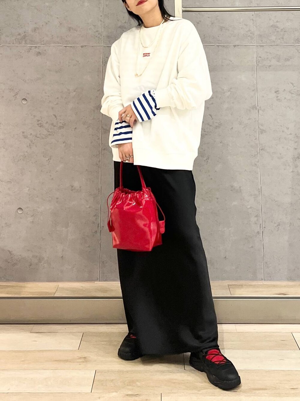 ブラック系のスカート、ブラック系のスニーカー、ホワイト系のスウェットを着用したレディースの冬コーディネートの1枚目の写真