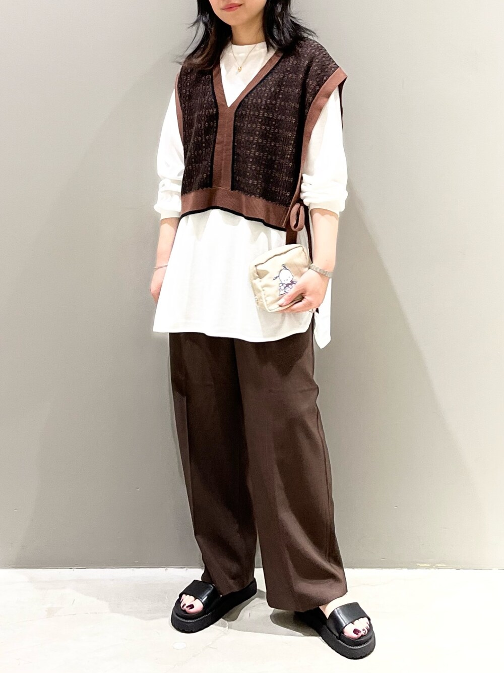 ブラウン系のスラックス、ブラック系のサンダル、ブラウン系のマタニティウェア/グッズを着用したレディースの秋コーディネートの1枚目の写真