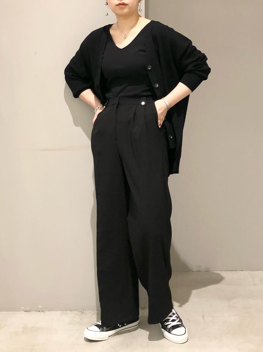 ブラック系のスニーカー、ブラック系のタンクトップ、ブラック系のスラックスを着用したレディースの春コーディネートの2枚目の写真