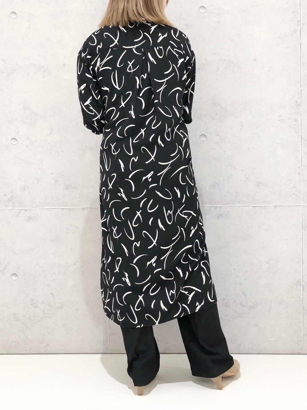 ブラック系のワンピース、ベージュ系のパンプス、シルバー系のショルダーバッグを着用したレディースの冬コーディネートの3枚目の写真