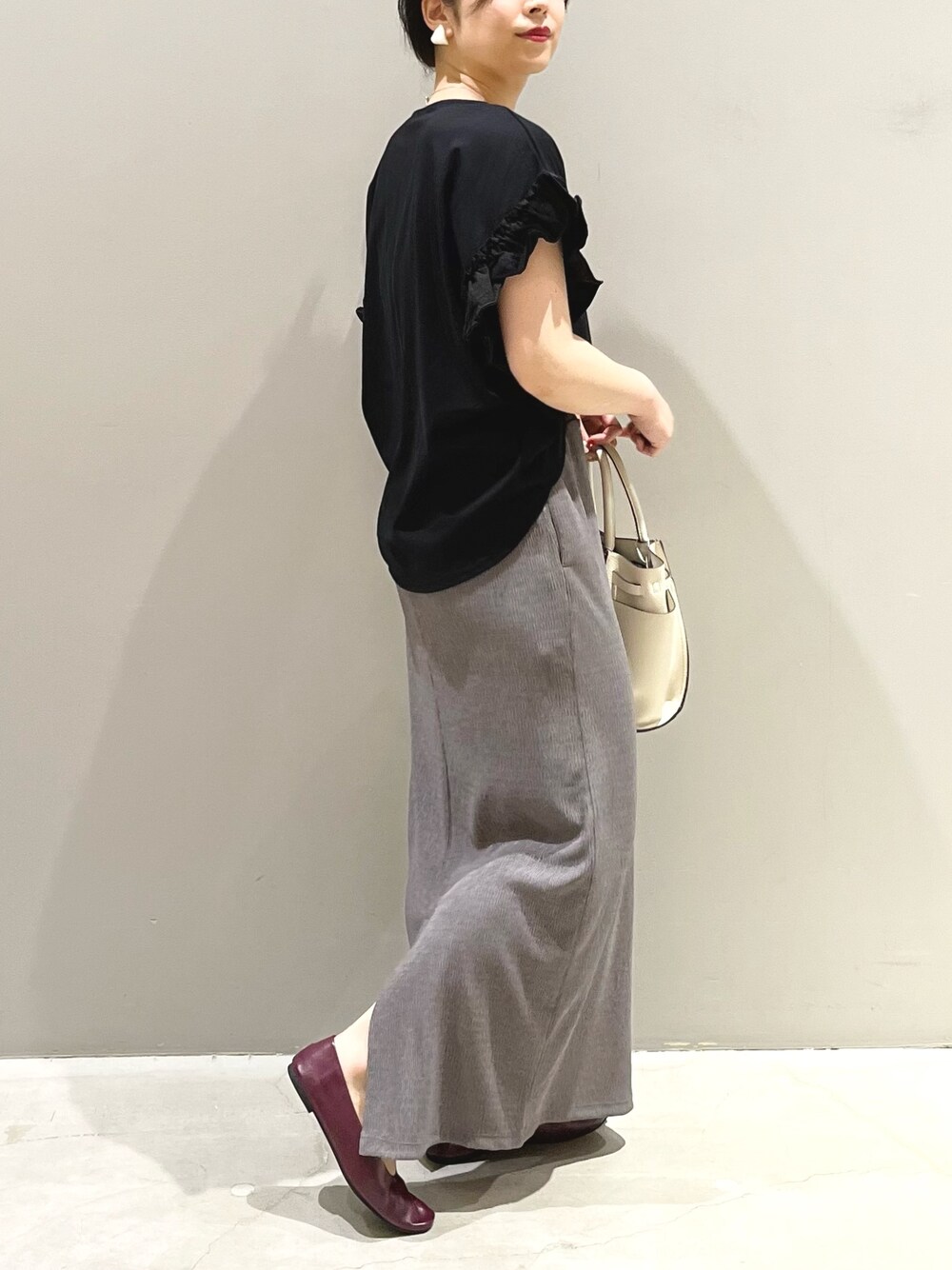 ブラック系のTシャツ/カットソー、ブラウン系のスカート、パープル系のパンプスを着用したレディースの夏コーディネートの2枚目の写真