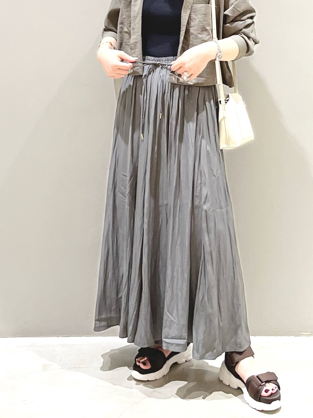 ホワイト系のショルダーバッグ、ブラウン系のサンダル、グレー系のその他パンツを着用したレディースの夏コーディネートの4枚目の写真