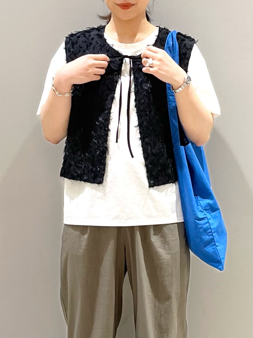 グリーン系のその他パンツ、ブラック系のサンダル、ブラック系のベストを着用したレディースの秋コーディネートの4枚目の写真