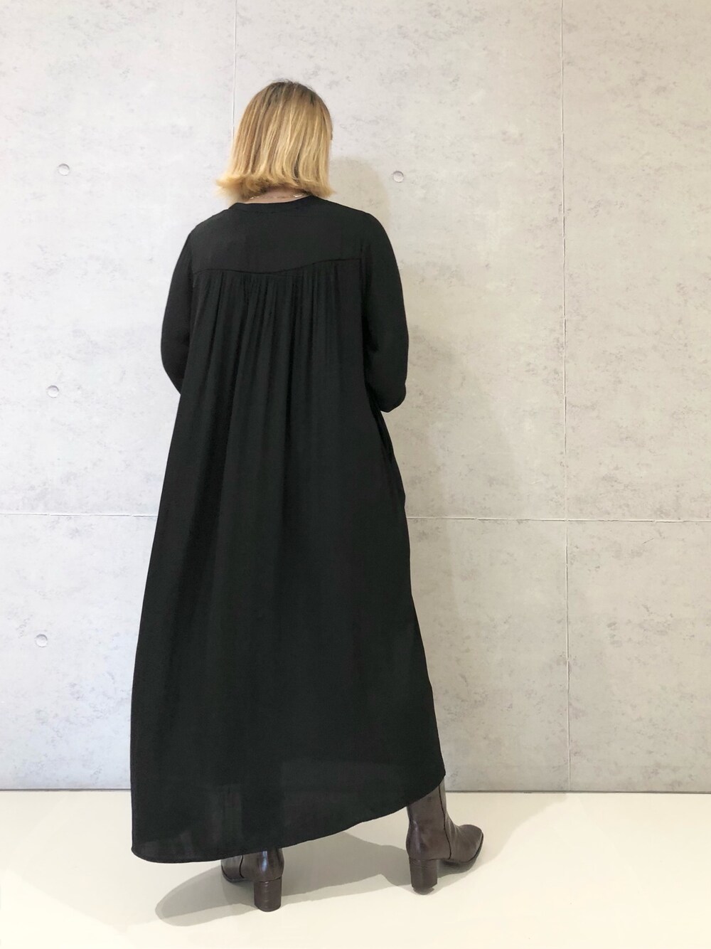 ブラック系のワンピース、ブラウン系のブーツを着用したレディースの冬コーディネートの3枚目の写真