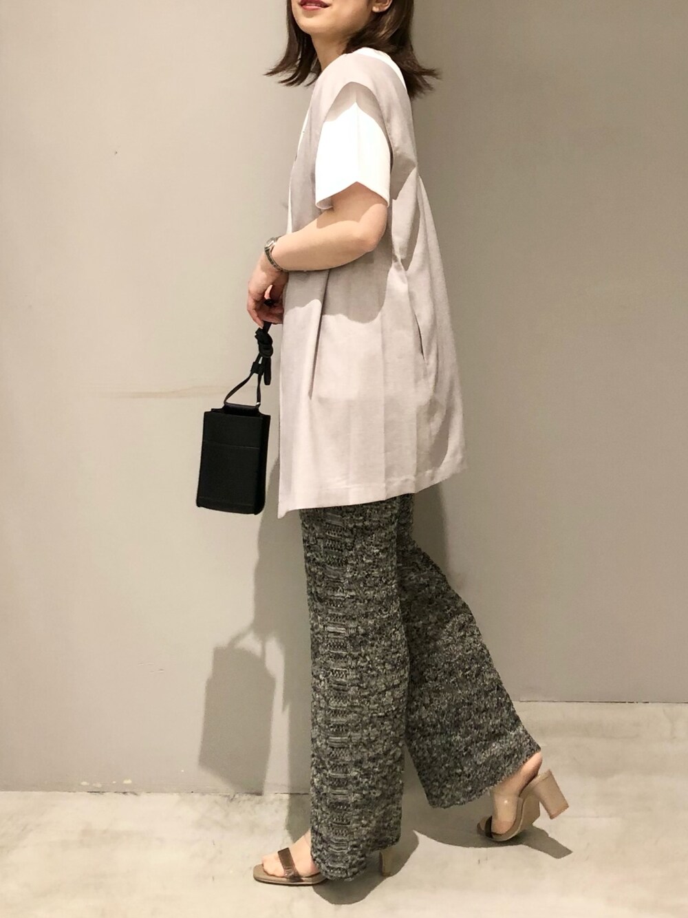 ベージュ系のベスト、ホワイト系のTシャツ/カットソー、ベージュ系のサンダルを着用したレディースの春コーディネートの3枚目の写真