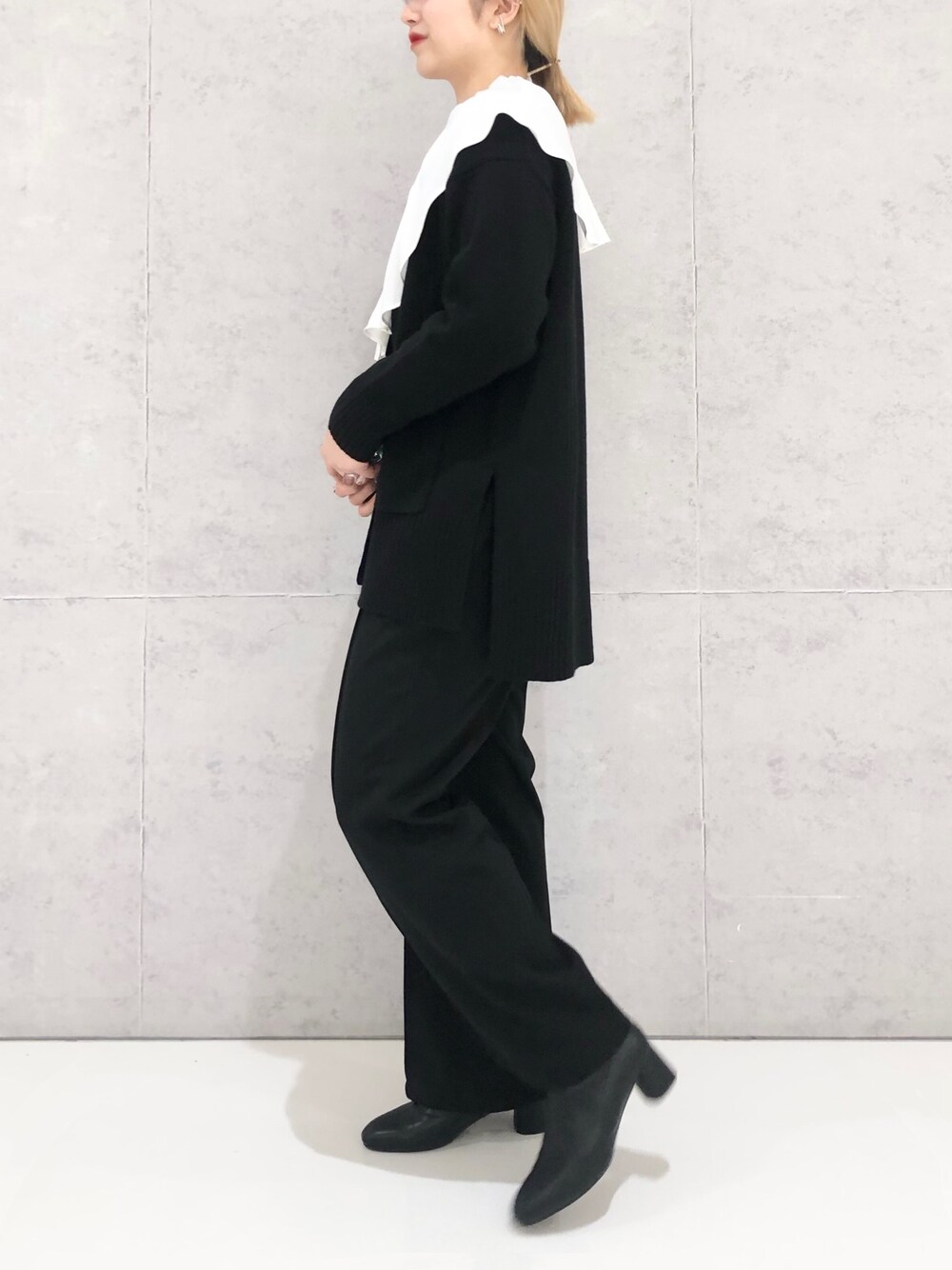 ブラック系のその他パンツ、ブラック系のブーツ、ホワイト系のシャツ/ブラウスを着用したレディースの冬コーディネートの2枚目の写真