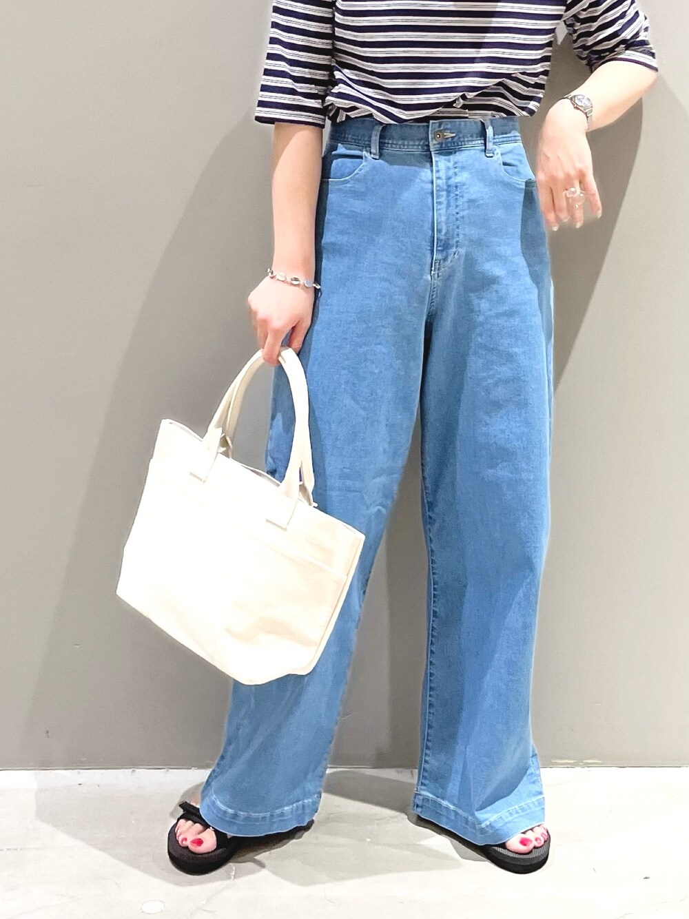 ブルー系のTシャツ/カットソー、ブルー系のデニムパンツ、ホワイト系のトートバッグを着用したレディースの夏コーディネートの5枚目の写真