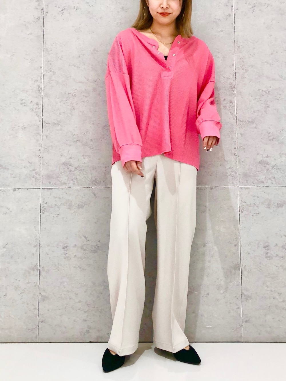 ベージュ系のスラックス、ブラック系のパンプス、ブラック系のタンクトップを着用したレディースの冬コーディネートの3枚目の写真