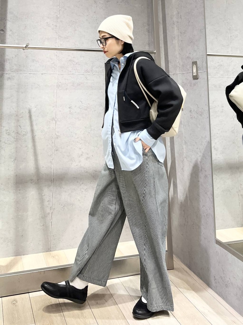 ブルー系のシャツ/ブラウス、ブラック系のボストンバッグ、ブラック系のパンプスを着用したレディースの冬コーディネートの1枚目の写真