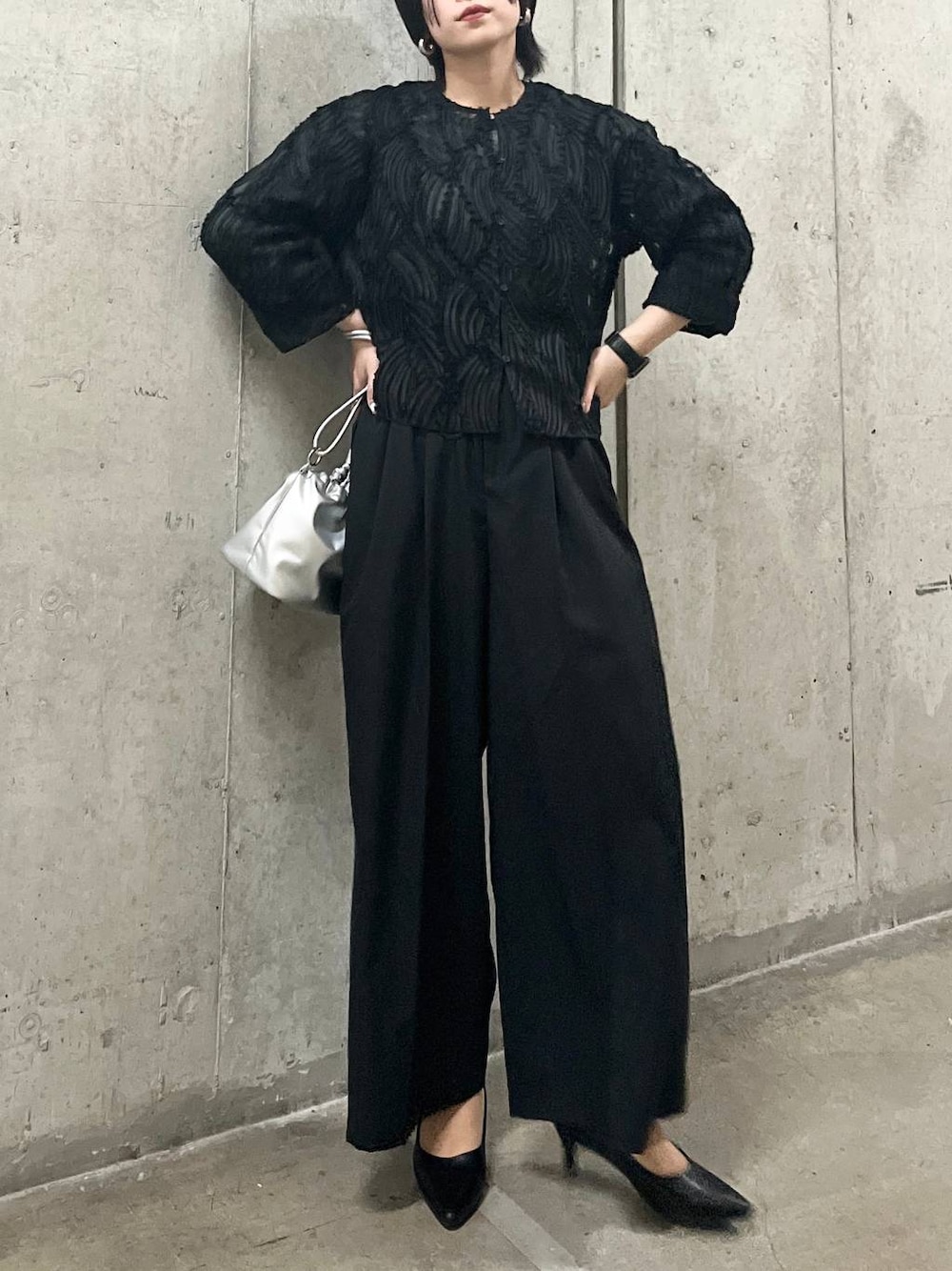 シルバー系のショルダーバッグ、ブラック系のシャツ/ブラウス、ブラック系のパンプスを着用したレディースの春コーディネートの1枚目の写真